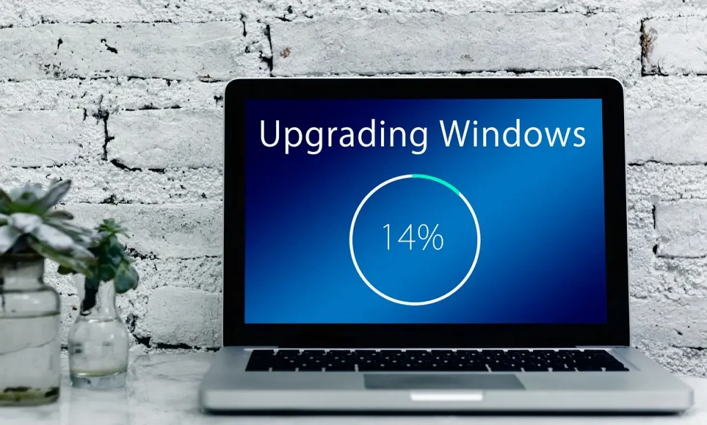 Ein Laptop mit der Anzeige Upgrading Windows und 14 Prozent!